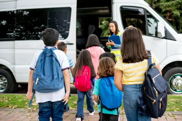 dzieci z plecakami wchodzą do busa